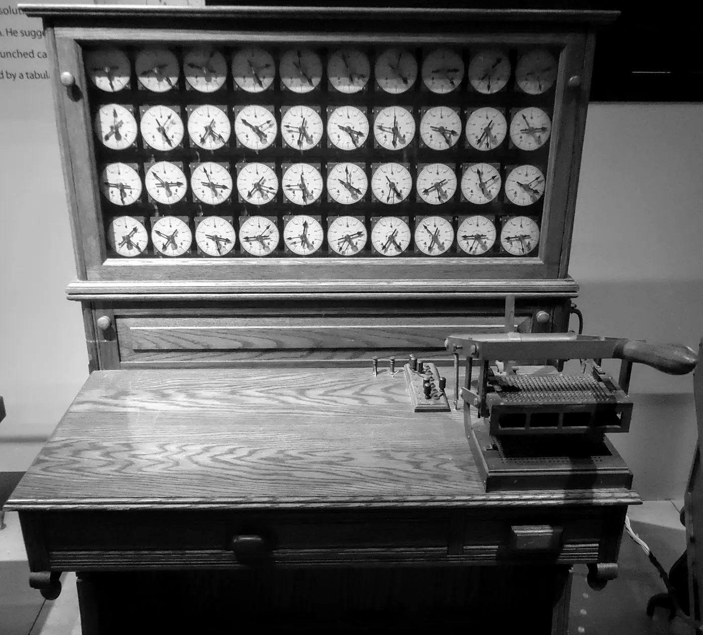 Hollerith-telmachine uit 1890 met wijzerplaten en kaartlezer op een houten bureau